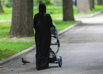 Muslim woman with a baby carriage
