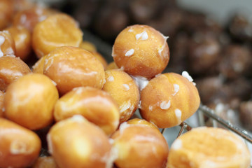 Donut holes on display racks at the donut shop.