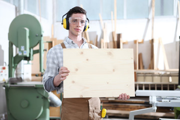 carpenter man show the wooden placard isolated on carpentry background