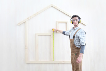 house construction renovation concept handyman carpenter worker man with meter  measure and show the model of a wooden house, custom solutions
