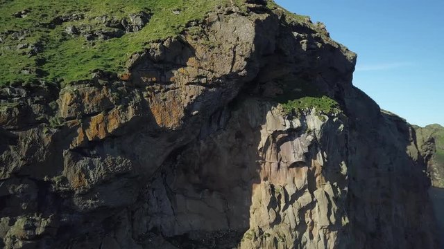 Panning aerial, coastal cliffs in Vestmannaeyjar