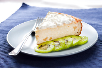 Homemade cottage cheese and semolina cake with kiwi fruit and cream on a plate