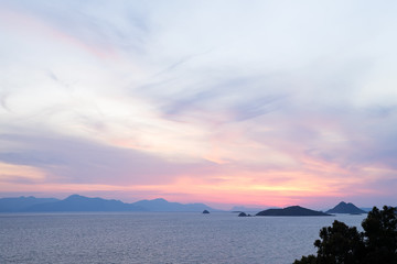 Amazing beach sunset with endless horizon and incredible foamy waves. Volcanic hills in the background.