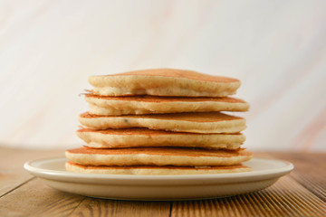 Stack of pancakes on wooden background. Homemade american pancakes, isolated.