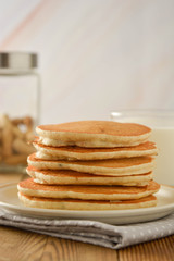 Stack of pancakes on wooden background. Homemade american pancakes, isolated.