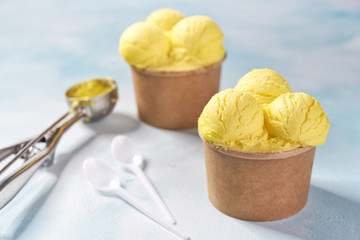 two portions lemon ice cream  on mint colors background and a mettal spoon waiting for filling, selective focus