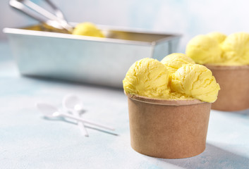 Yellow ice cream scooped out of container.  Ice cream balls.