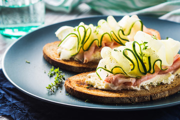Rye bread open sandwiches with cucumber, ham and fresh cheese.