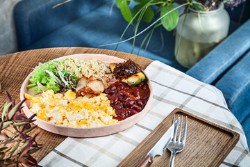 Continental breakfast. Modern Full English Breakfast with scrambled eggs, bulgur, beans, avocado and lettuce. Healthy food with copy space. Served lunch in cafe