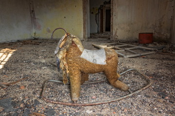 old damaged rocking horse in an abandoned house