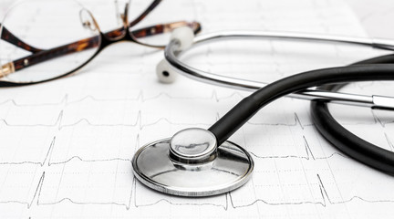 Stethoscope with eyeglasses on the cardiogram.