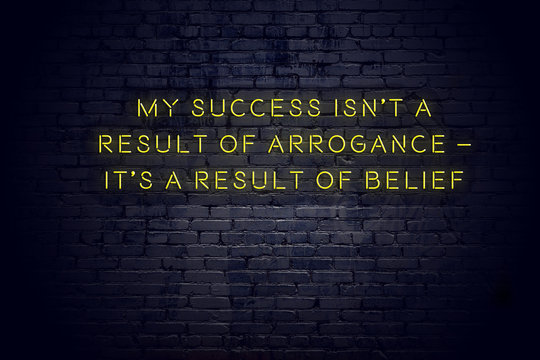 Neon sign with positive wise motivational quote against brick wall 