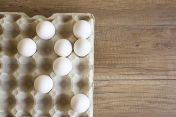 White chicken eggs in a cardboard tray. Copy spase