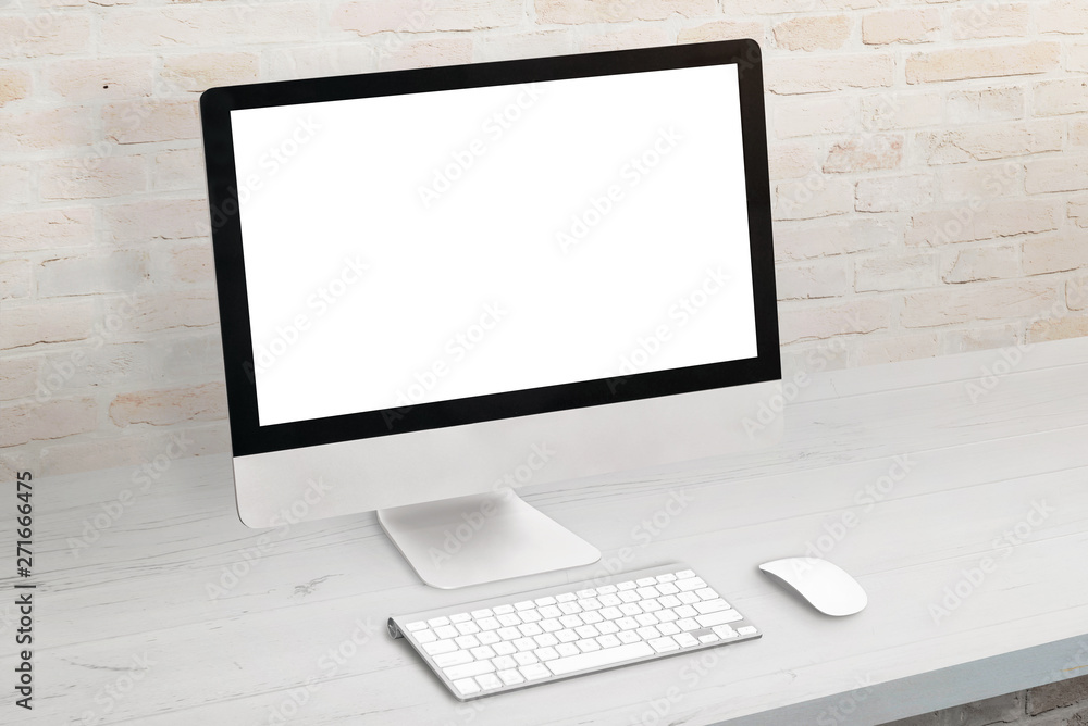 Poster Computer display on white desk. Keyboard and mouse beside. Modern office brick wall in background. Isolated screen for mockup, app or website presentation.
