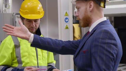 Businessman scolding factory engineer