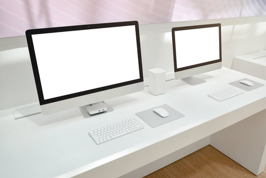 Two computers with isolated screens for mockup on office desk.