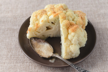 Boiled whole cauliflower covered with butter and breadcrumbs