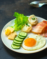 Fototapeta na wymiar breakfast - fried eggs, lettuce, lettuce, cucumbers, asparagus, bacon, sauce and more. top. food background. space for text and lettering
