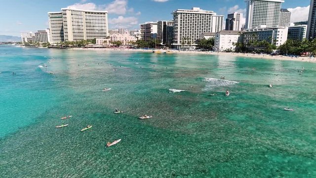 Flying over people on paddle boards towards Waikiki beach, Hawaii.