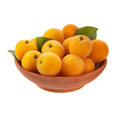 heap of apricots with green leaves  in wooden cup isolated on white background