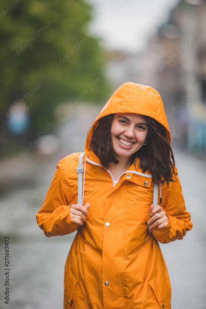 Poster young pretty smiling woman portrait in raincoat with hood