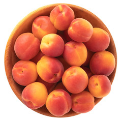 heap of red apricots in wooden plate isolated on white background. top view