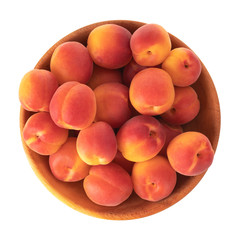heap of red apricots in wooden plate isolated on white background. top view