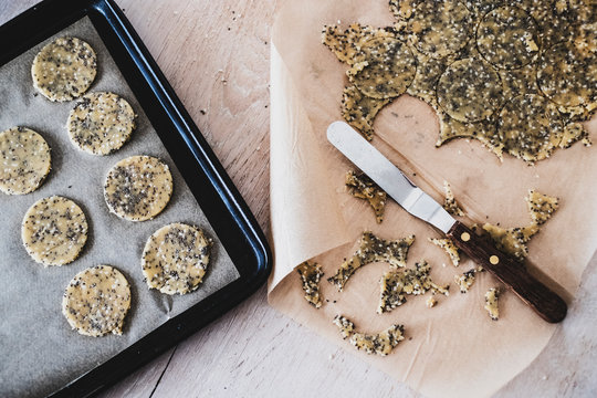 High angle close up of seeded cracker dough on a baking tray.