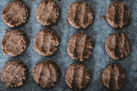 High angle close up of chocolate cookie dough on a baking tray.