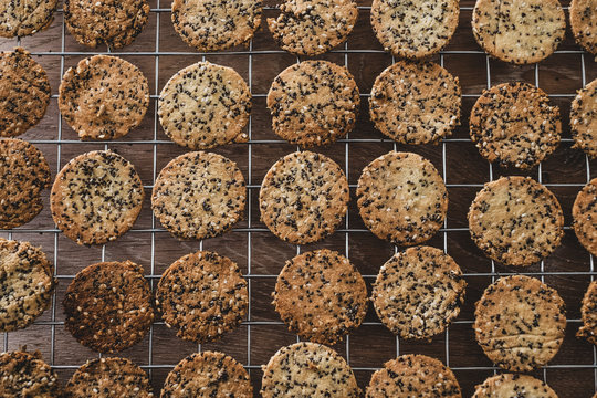 High angle close up of freshly baked seeded crackers on a baking tray.