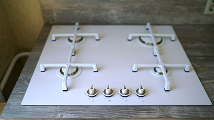 White modern gas stove. Macro closeup of modern luxury gas stove top with tiled backsplash