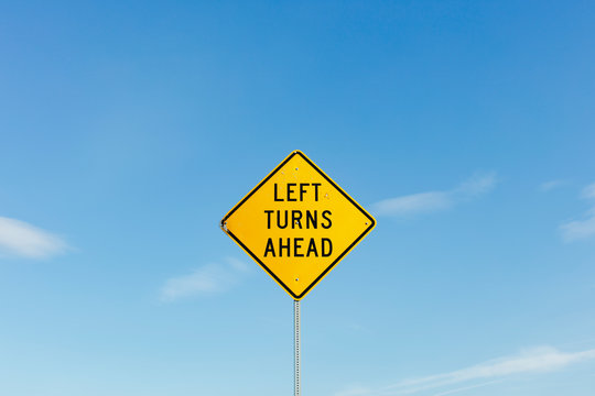 Left Turns Ahead yelloow traffic sign,Left Turns Ahead sign, blue sky in background