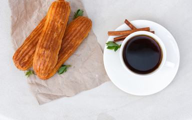 Fragrant coffee with eclairs in the summer cafe.
