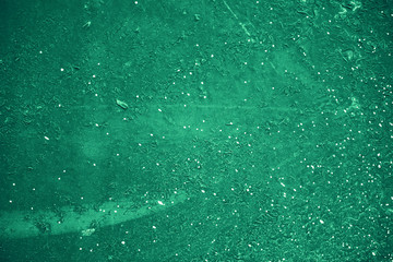 Vintage green background. Rough painted wall of emerald color. Imperfect plane of virid colored. Uneven old decorative toned backdrop of green tint. Texture of emerald hue. Ornamental stony surface.