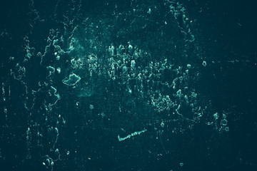 Vintage azure background. Rough painted wall of turquoise color. Imperfect plane of cyan colored. Uneven old decorative toned backdrop of aqzure tint. Texture of teal hue. Ornamental stony surface.