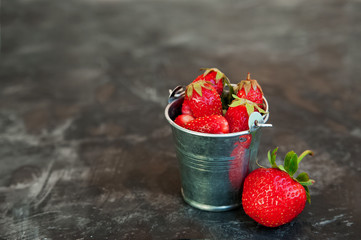 Natural texture of ripe strawberries. Banner of strawberries in a miniature galvanized bucket close-up and copy space.