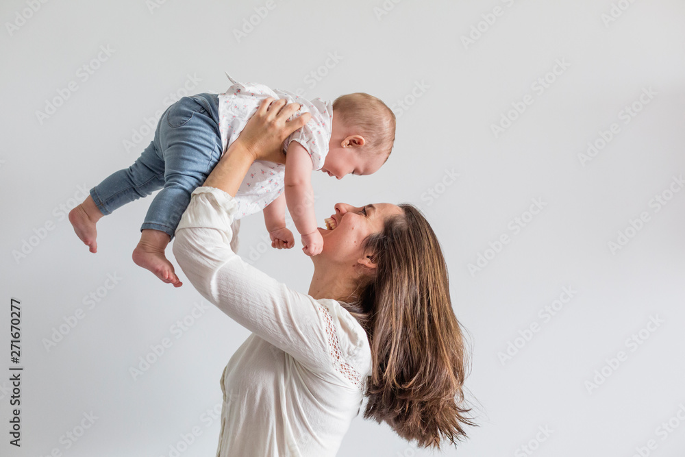 Wall mural portrait of a beautiful baby girl and her mother at home. family concept indoors. daytime and lifest