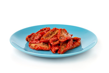 Dried tomatoes on a white background. Slices of dried tomatoes in oil on a plate.