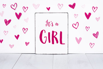 It's a girl new born baby text on sign board with cute little pink hearts on white background