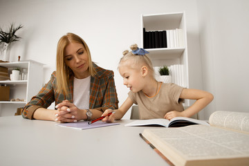 Preschool girl studying with mother at home