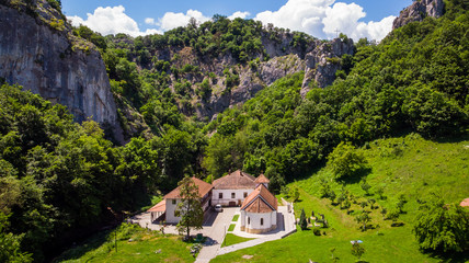 Fototapeta na wymiar Small monastery Vratna in Serbia under the big stone, surrounded with forest