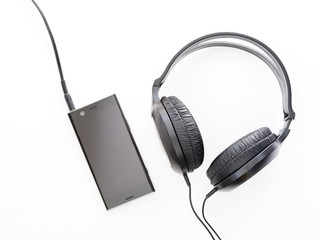 black headphones and black smartphone on white background