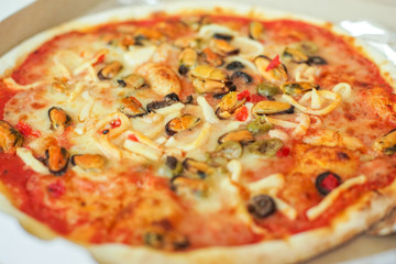 Pizza with seafood - mussels, olives. Side view