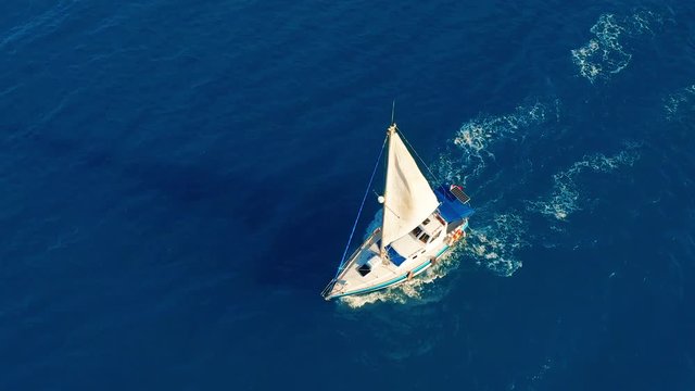 Aerial view. Yacht sailing on open sea at sunny day. Sailing boat.