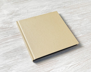 Fototapeta premium Closed blank square brochure on light wooden background.