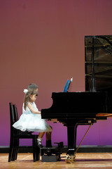 発表会でピアノを弾く兄妹(9歳と4歳)