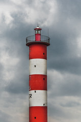 Lighthouse of Port-La-Nouvelle in red and white on cloudy sky