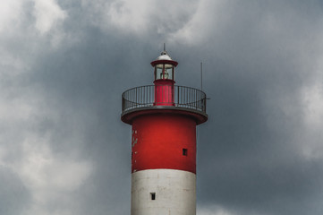 Lighthouse of Port-La-Nouvelle in red and white on cloudy sky
