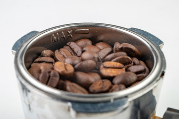 Black roasted coffee beans and a coffee machine flask. Coffee making accessories.