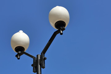 Vintage iron lantern on a city street against the blue sky